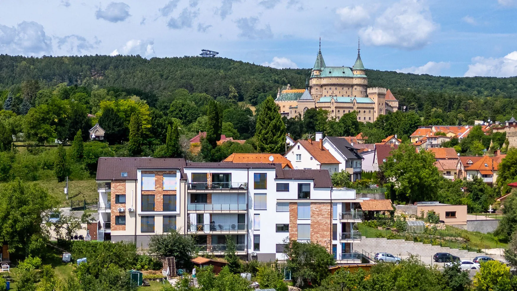 Rezidencia Pod zámkom: Letecký pohľad na biele apartmány Cintorínska s tehlovými prvkami pod Bojnickým zámkom.